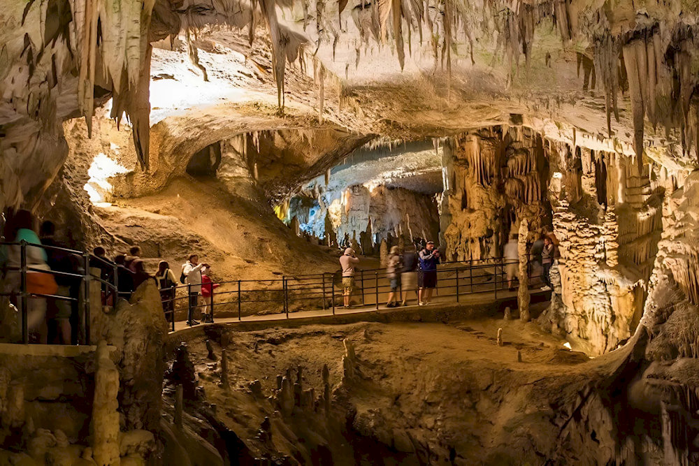 It’s advisable to wear sturdy shoes and bring a flashlight, as parts of the cave can be dimly lit